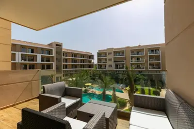 a balcony with chairs and a pool and buildings at Bonjour cher client in Marrakech