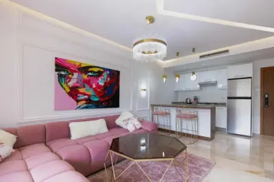 a living room with a pink couch and a painting at Bonjour cher client in Marrakech