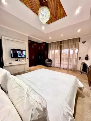 a large bedroom with a large white bed with a tv at Medley Luxury Villa - PARKING, WIFI & PISCINE in Marrakech
