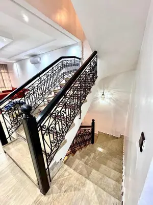a spiral staircase with black railing in a building at Medley Luxury Villa - PARKING, WIFI & PISCINE in Marrakech