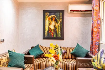 a living room with a couch with a painting on the wall at 5-Star Atlas Pearl well Centered in Marrakech