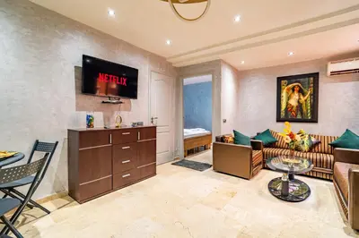 a living room with a couch and a tv on the wall at 5-Star Atlas Pearl well Centered in Marrakech