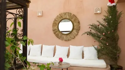 a living room with a white couch and a mirror at Le RIAD Paradis Secret in Marrakech