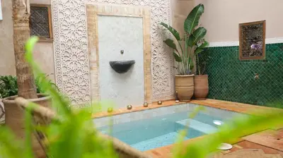 a small swimming pool in a room with plants at Le RIAD Paradis Secret in Marrakech
