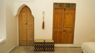 a room with a large wooden door and two boxes at Le RIAD Paradis Secret in Marrakech