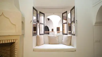 a white couch in a room with a fireplace at Le RIAD Paradis Secret in Marrakech
