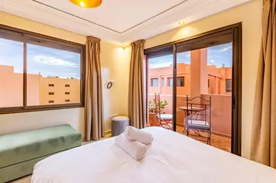 a bedroom with a bed and a large window at Coup de coeur en plein centre ville piscine in Marrakech