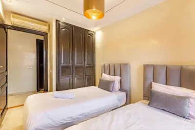 two beds sitting next to each other in a bedroom at Coup de coeur en plein centre ville piscine in Marrakech
