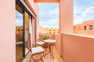 a balcony with a table and two chairs and a window at Coup de coeur en plein centre ville piscine in Marrakech