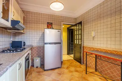 a kitchen with a white refrigerator in a room at Coup de coeur en plein centre ville piscine in Marrakech