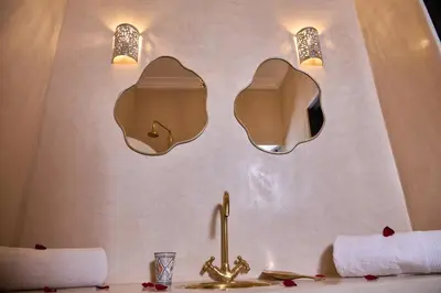 a bathroom with two mirrors and a sink at Riad Tawkane in Marrakech