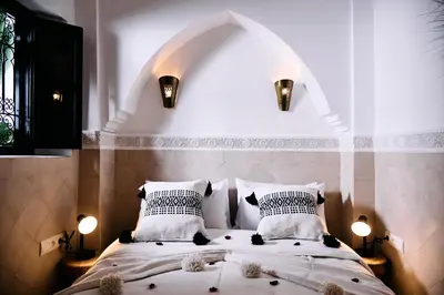 a bedroom with a large bed with two pillows at Riad Tawkane in Marrakech
