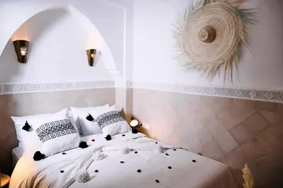 a bedroom with a white bed with a window at Riad Tawkane in Marrakech