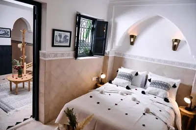 a bedroom with a large white bed in a room at Riad Tawkane in Marrakech