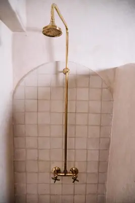 a shower in a bathroom with a tiled wall at Riad Tawkane in Marrakech