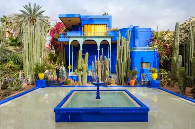 a blue building with a fountain in the middle of a garden at Cozy Studio center of Marrakech in Marrakech
