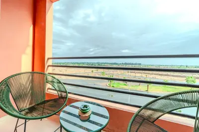 a table and chairs on a balcony with a view of the beach at 2Br Apartment 15 min from Jemaa el-Fnaa Marrakech in Marrakech