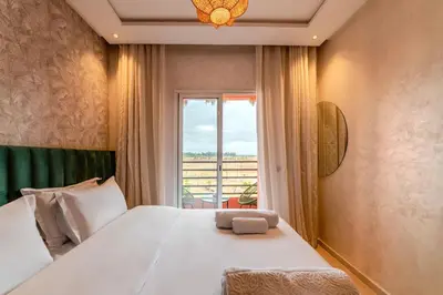 a bedroom with a large white bed with a window at 2Br Apartment 15 min from Jemaa el-Fnaa Marrakech in Marrakech