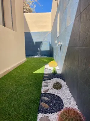 a garden with rocks and plants on the side of a building at Maison du Bonheur à Marrakech in Marrakech