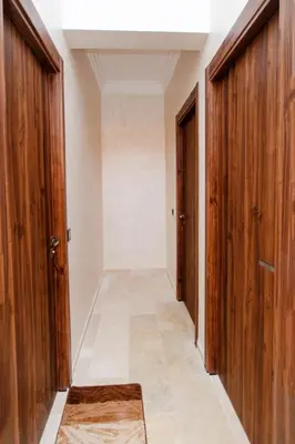 an empty hallway with wooden doors and a rug at Appartement Duplex Hivernage in Marrakech