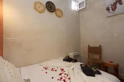 a bedroom with a bed with a clock on the wall at Riad Bahia BenSaleh in Marrakech