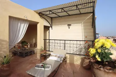 a balcony with a white couch and a table at Riad Bahia BenSaleh in Marrakech