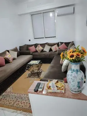 a living room with a couch and a vase of flowers at Quiet and family apartment, appartement in Marrakech