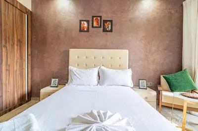 a bedroom with a large white bed with pictures on the wall at 5-Star Suite in Prime Spot with Luxe Touches in Marrakech