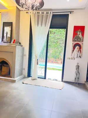 a room with a fireplace and a window with a curtain at Villa M à Marrakech in Marrakech
