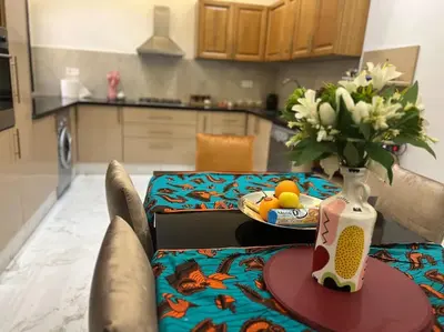 a table with a bowl of fruit and a vase of flowers at Villa M à Marrakech in Marrakech