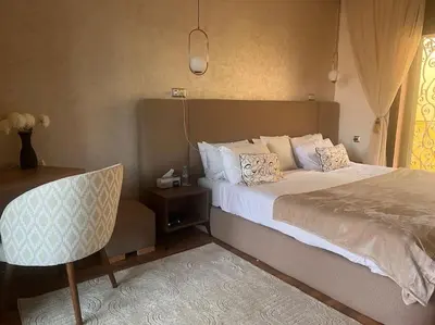 a bedroom with a large bed and a chair at Villa M à Marrakech in Marrakech