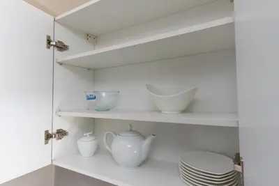 a kitchen with white shelves and bowls and plates at Appartement au cœur de Marrakech in Marrakech