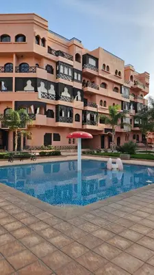 a large apartment building with a swimming pool and an umbrella at Amazing view, apartment in Marrakech in Marrakech