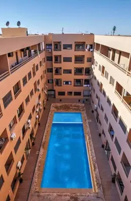 an overhead view of a swimming pool between two buildings at Appartement au centre de Gueliz, hivernage in Marrakech
