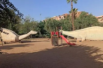 a playground with a plastic dinosaur and a slide at Charm Apt dans le triangle Tourisme de Marrakech ! in Marrakech