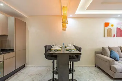 a dining room with a table and a couch at Charm Apt dans le triangle Tourisme de Marrakech ! in Marrakech
