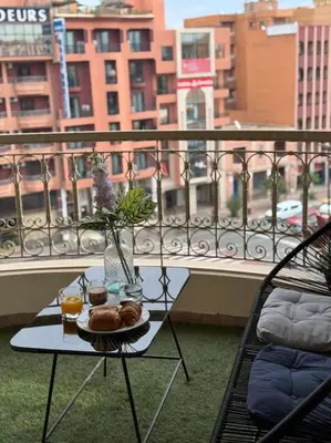 a table with a plate of food on a balcony at Appart au Cœur de Gueliz in Marrakech