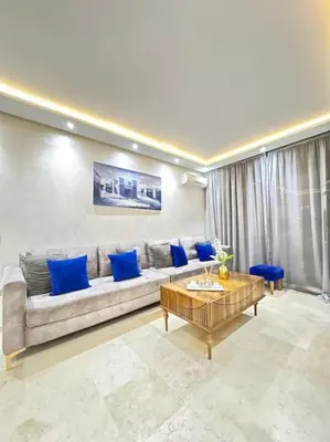 a living room with a couch and blue pillows at Appart au Cœur de Gueliz in Marrakech
