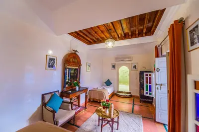 a living room with a bed and a table at Riad LAMDINA in Marrakech
