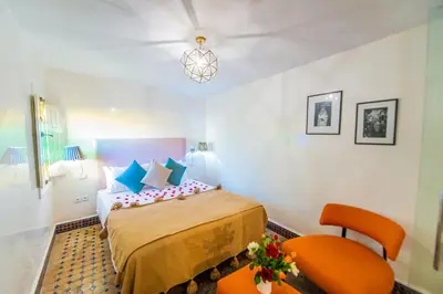 a hotel room with a bed and two chairs at Riad LAMDINA in Marrakech