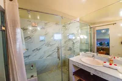 a bathroom with a glass shower and a sink at Riad LAMDINA in Marrakech