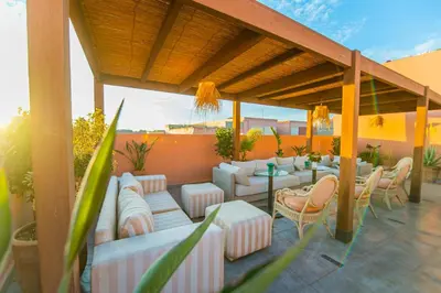 a patio with white couches and tables and chairs at Riad LAMDINA in Marrakech