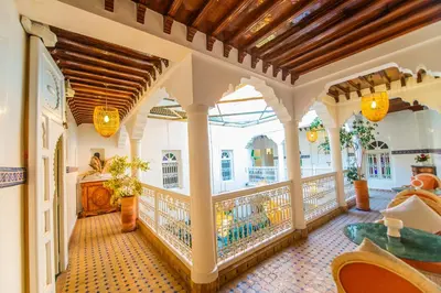 a room with a balcony with a table and chairs at Riad LAMDINA in Marrakech