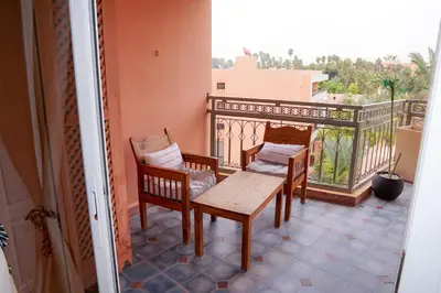 a balcony with two chairs and a table on a balcony at Suite Majorelle - Luxe-Terasse-Parking privée in Marrakech