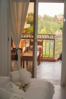 a bedroom with a bed and a balcony with a view at Suite Majorelle - Luxe-Terasse-Parking privée in Marrakech