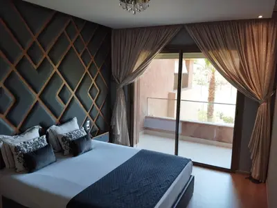 a bedroom with a bed and a large window at Appartement de luxe Prestigia in Marrakech