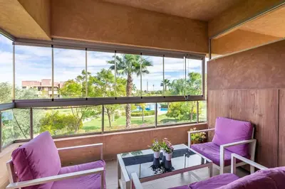a room with purple chairs and a table and windows at Stunning Prestigia Escape Poolside Views in Marrakech