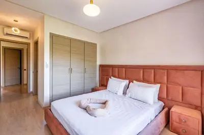a bedroom with a large bed with a large headboard at Stunning Prestigia Escape Poolside Views in Marrakech