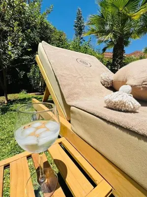 a glass of wine sitting on a table next to a couch at Villa avec piscine chauffée en option Palmeraie in Marrakech