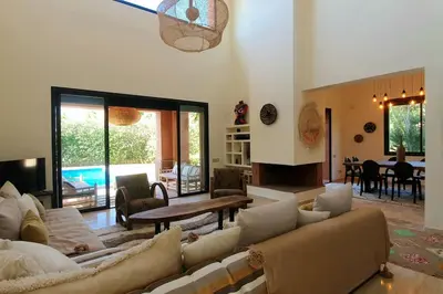 a large living room with couches and a table at Villa avec piscine chauffée en option Palmeraie in Marrakech